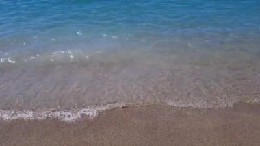 Deniz mavisi dalgalar kumsalda kırılır.