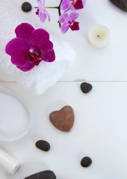 Ajuste de spa con orquídeas rosadas, piedras negras y sales de baño sobre fondo de madera. — Foto de Stock