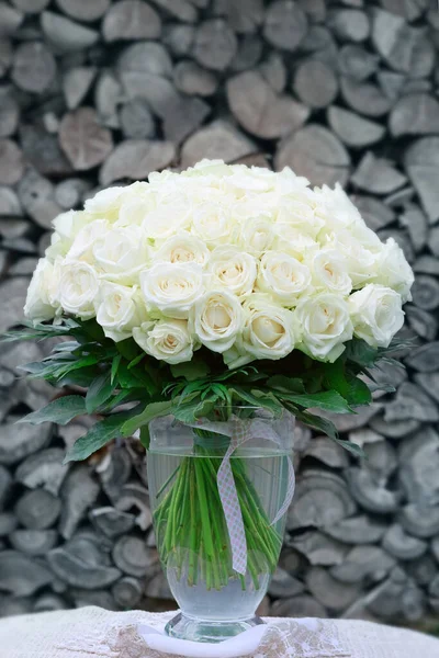 Buquê de rosas brancas em um vaso de vidro em fundo cinza. — Fotografia de Stock