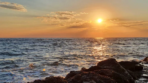 Pôr do sol colorido com grande sol sob as ondas do mar. — Fotografia de Stock