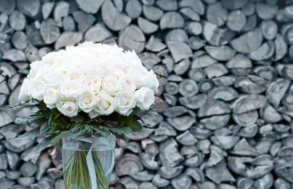 Kytice z bílých růží ve skleněné váze na šedém pozadí. — Stock fotografie