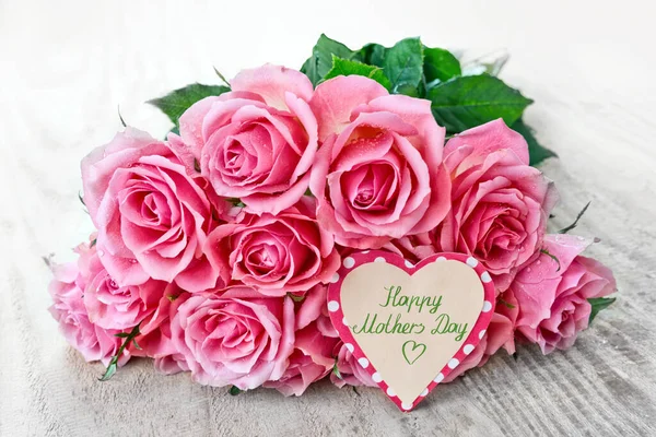 Tarjeta Happy Mothers Day con rosas rosadas sobre fondo de madera. — Foto de Stock