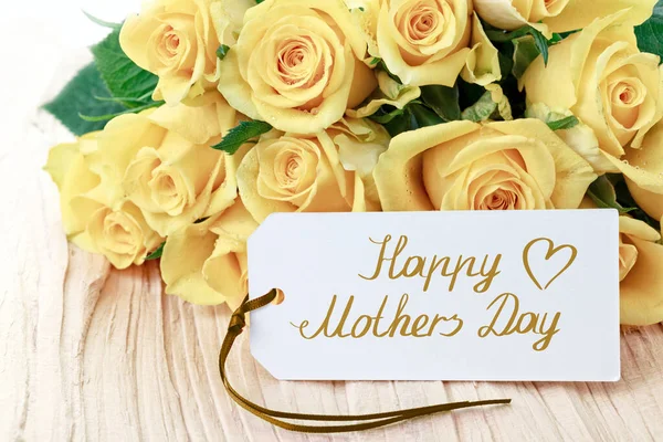Tarjeta Happy Mothers Day con rosas amarillas sobre fondo de madera. — Foto de Stock