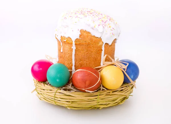 Easter eggs in the wicker basket and homemade cake . — Stock Photo, Image