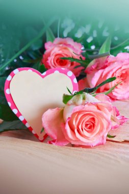 Ahşap arka planda pembe güller olan anneler günü kartın kutlu olsun..