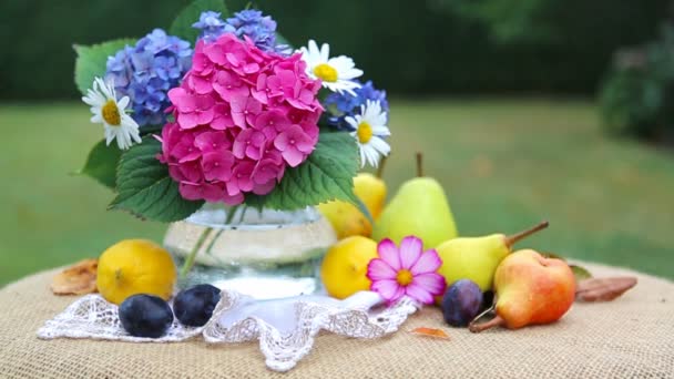 五颜六色的花花束在玻璃花瓶和新鲜的混杂的果子 . — 图库视频影像