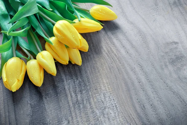 Tahta zemin üzerinde sarı laleler olan Anneler Günün kutlu olsun..