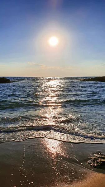 Pôr do sol colorido com grande sol sob as ondas do mar. — Fotografia de Stock