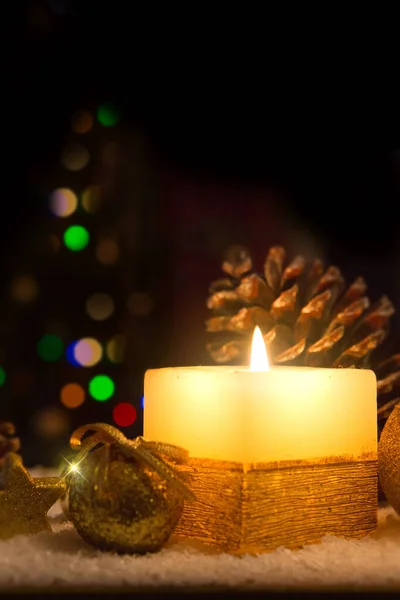 Advent candle and christmas decoration isolated on blur background. Christmas background with snow,candle and bauble.