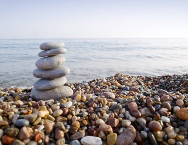 Deniz taşları piramidi, deniz tarafından oluşturulmuş. Nesne odaklı, arkaplan bulanık.