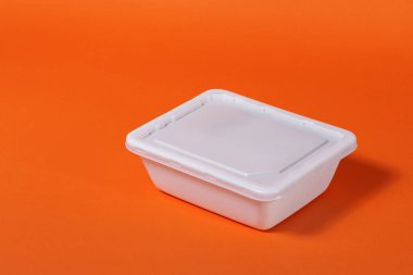 Turuncu arka planda beyaz plastik fast food kutusu - yan görünüm, izole