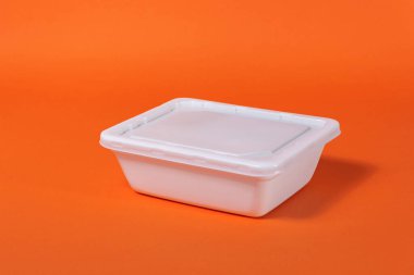 Turuncu arka planda beyaz plastik fast food kutusu - yan görünüm, izole