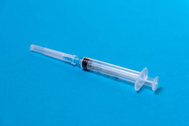 Mavi arkaplan, üst görünüm, metin için bir adet tek kullanımlık plastik şırınga