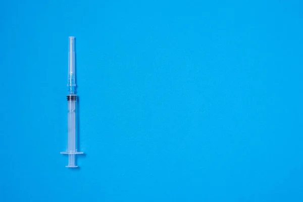 Mavi arkaplan, üst görünüm, metin için bir adet tek kullanımlık plastik şırınga