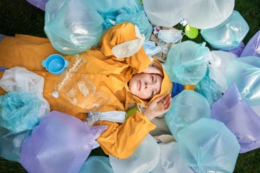 Gezegeninde birikmiş bir sürü çöp torbasıyla ne yapacağını düşünen bir kadın.
