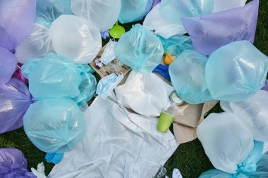 Plastik torbalar, kullanılmış koruyucu maskeler ve şişelerle dağınık ve dağınık bir zemin.