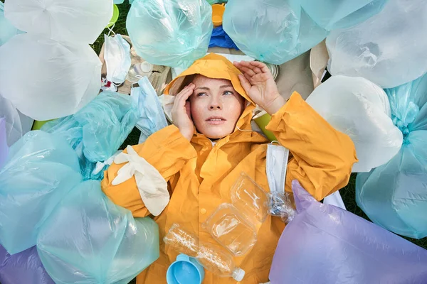 Gezegeninde birikmiş bir sürü çöp torbasıyla ne yapacağını düşünen bir kadın.