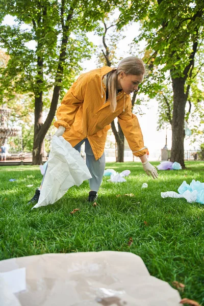 Parkı temizlerken koruyucu eldiven giyen aktif çevreci.