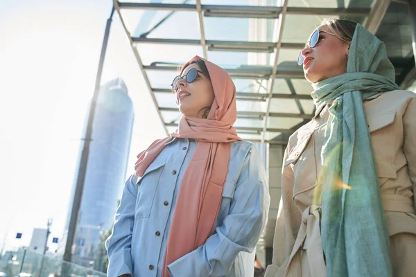 Két modern arab lány fejkendőben, akik figyelmesen néztek valamit. — Stock Fotó