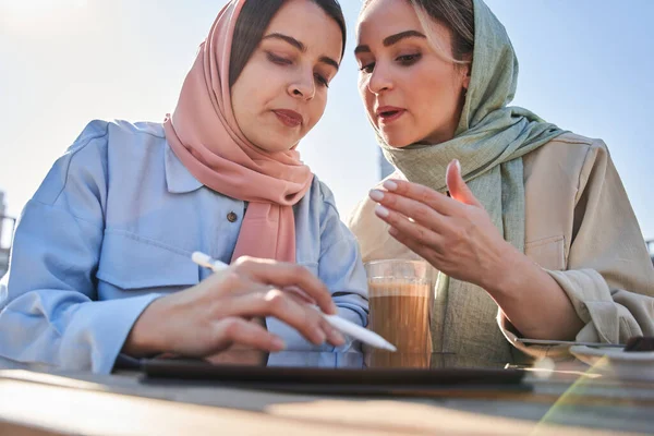 Iszlám nő gesztikulál és tanácsokat ad női kollégájának, miközben megvitatja — Stock Fotó