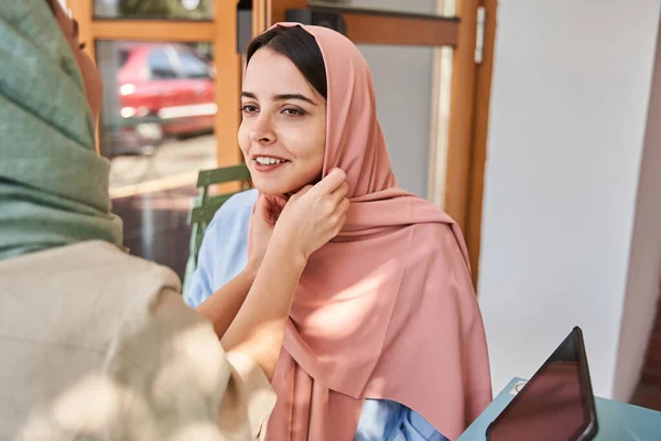 Retrato de la cuidadosa mejor amiga ayudando a tomar a Abaya con su novia musulmana —  Fotos de Stock