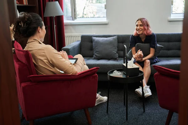 Girl with pink hair looking at therapist with happy expression after successful session — Stock Photo, Image