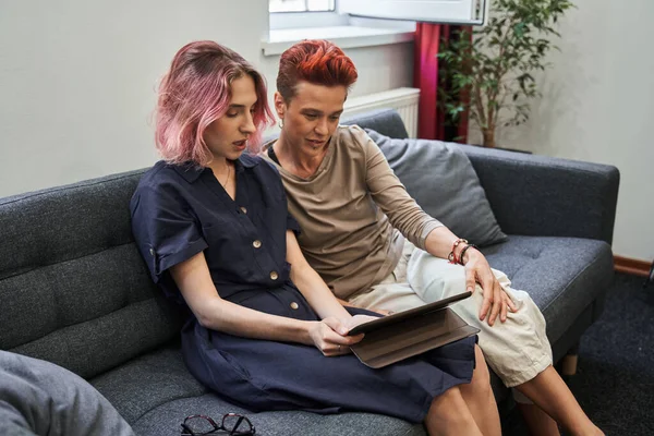 Spokojne młoda kobieta i jej smutna żona o terapii małżeńskiej online podczas korzystania z tabletu — Zdjęcie stockowe