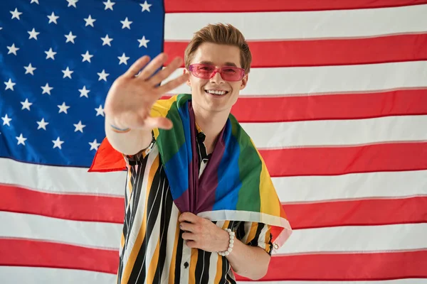 Hombre americano de pie con arco iris gay orgullo bandera y sentirse seguro y feliz — Foto de Stock