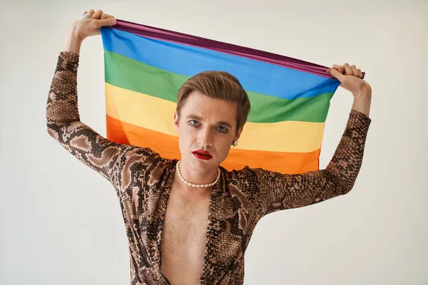 Hombre femenino posando con la bandera del arco iris mientras celebra el evento del festival del orgullo gay — Foto de Stock