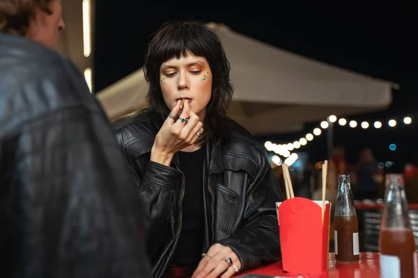 Avslappnad kvinnlig person sitter på caféet med sin pojkvän och röker cigarett — Stockfoto