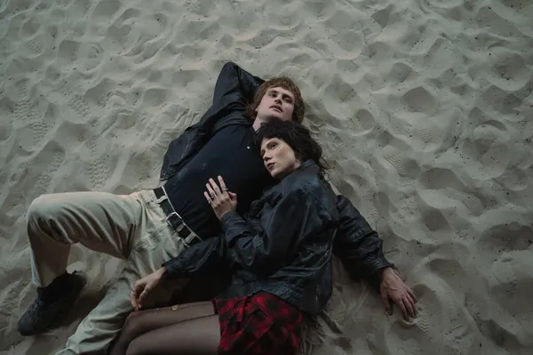 Brunett flicka omfamna sin pojkvän samtidigt koppla av tillsammans på natten stranden — Stockfoto