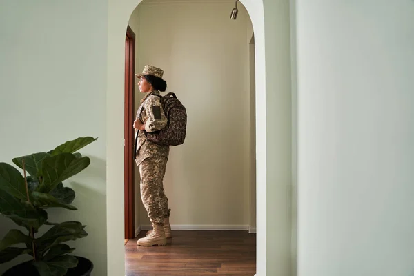 Mujer soldado mirando a la puerta con emociones tristes mientras va a luchar —  Fotos de Stock