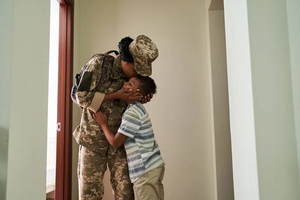 Menino beijando com sua mãe soldado enquanto vê-la para o exército — Fotografia de Stock