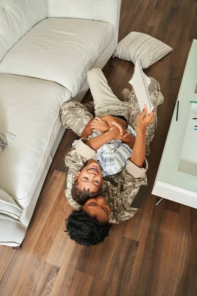 Alegre negro madre y hijo acostado en el suelo — Foto de Stock
