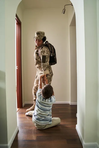 Preto menino segurando a mão de sua mãe no chão — Fotografia de Stock