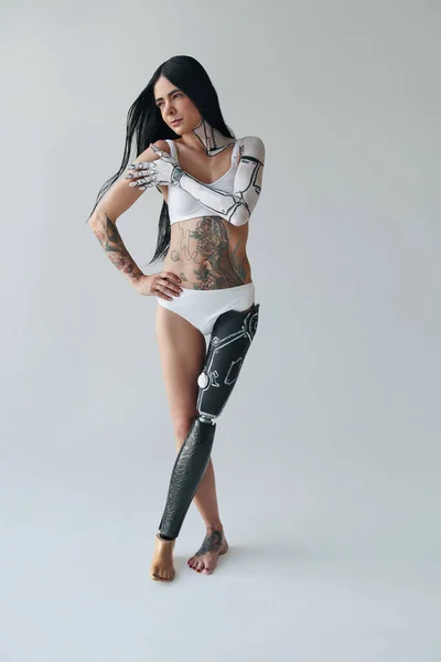 Volledige weergave van de getatoeëerde vrouw met kunstmatige been en cyber body art poseren in de studio. Ongewoon uiterlijk concept. Voorraadfoto — Stockfoto
