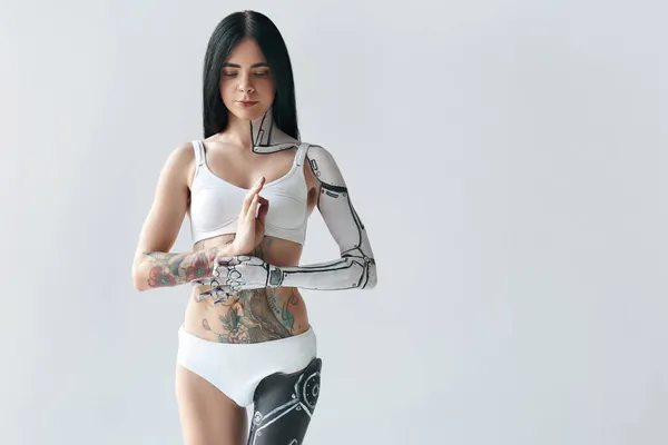 Брюнетка татуированная девушка с киборг-искусством тела и искусственной ногой медитирующей спокойно — стоковое фото