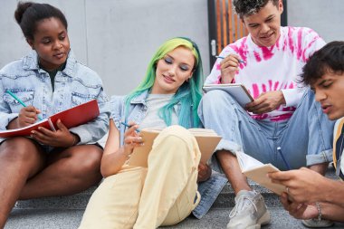 Şehirde ödev yapan farklı ırktan arkadaşlar.