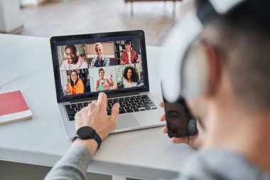 Zoom konferansı sırasında bilgisayarının klavyesinde yazan adam