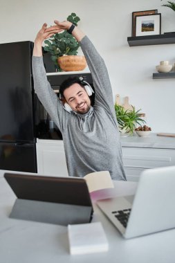 Evde dizüstü bilgisayarla çalışırken kulaklık takmaktan yorulmuş.