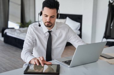 Çağrı merkezinin özel kulaklıkla tablet üzerinde yazan konsantre operatörü