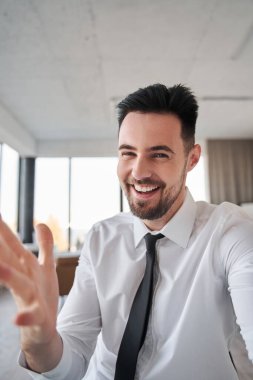 İş adamı video görüşmesi yaparken meslektaşlarıyla bir şey tartışıyor.