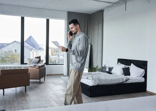 Hombre persona pasar tiempo en el dormitorio mientras charla con alguien en el teléfono inteligente — Foto de Stock