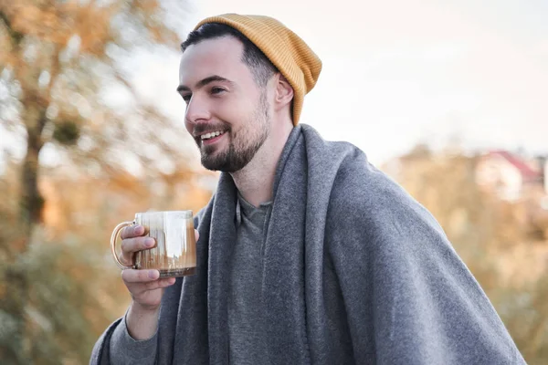 Killen håller kopp kaffe och ler toothy medan du tillbringar morgonen på balkongen — Stockfoto