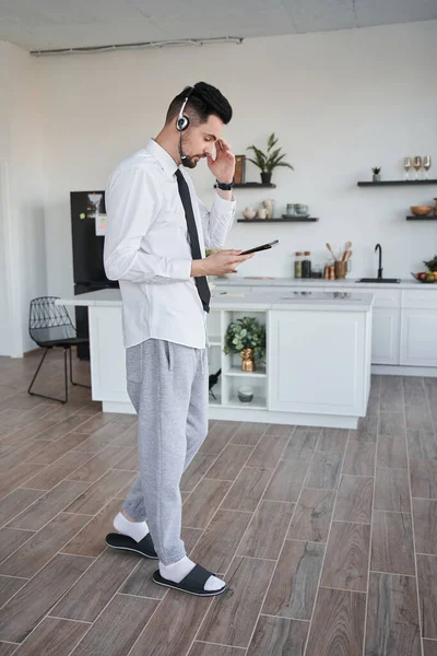 Менеджер носить гарнітуру, що стоїть у його квартирах і спілкується з кимось — стокове фото