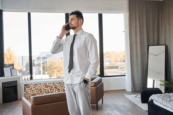 Empresario parado en sus apartamentos y conversando en el teléfono móvil — Foto de Stock