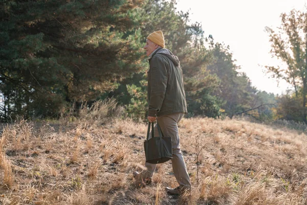 Senior hält Tasche mit Pilzen und schaut weg — Stockfoto