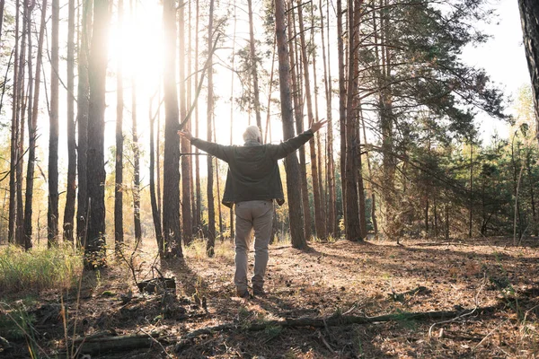 Verheugde oude man voelt zich vrij tijdens het reizen in het bos in de herfst — Stockfoto