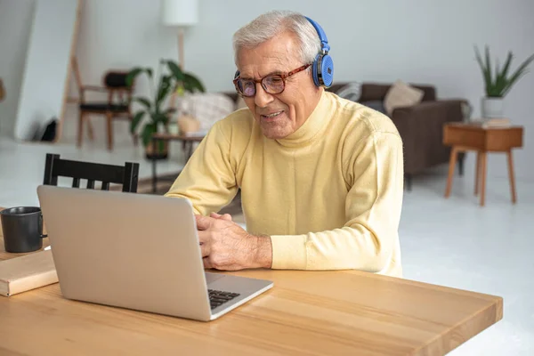 Homme en lunettes portant des écouteurs impliqués dans l'étude sur les cours en ligne — Photo