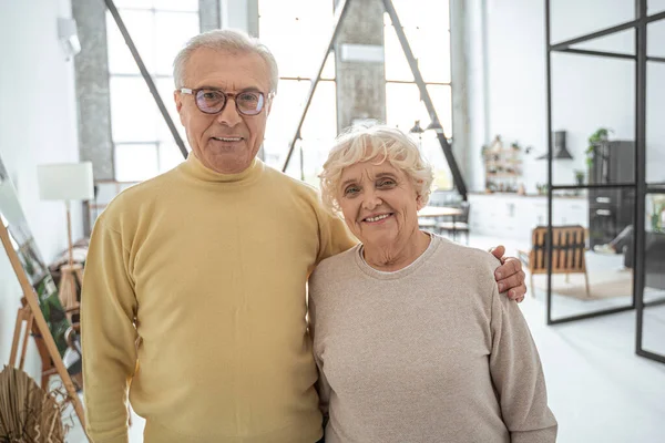 Oudere man en vrouw genieten van gezellige tijd samen terwijl omarmen thuis — Stockfoto